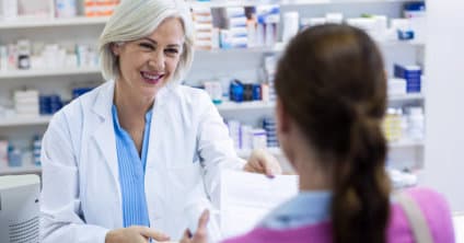 pharmacist holding prescription from customer